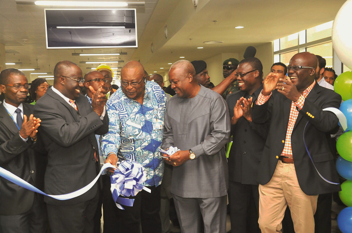 President Mahama being assisted by Air Vice Marshall Christian Dovlo (left), Board Chairman of GCAA, to cut the ribbon to officially inaugurate the GCAA Training Academy. Among them are some board members of the authority